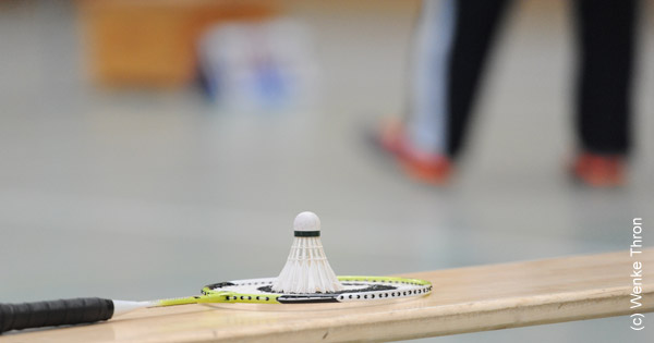 Schläger und Federball, die auf einer Bank liegen Schläger und Federball, die auf einer Bank liegen