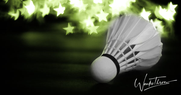 Auf dem Foto ist ein Federball zu sehen mit einem Sternbokeh als Hintergrund.